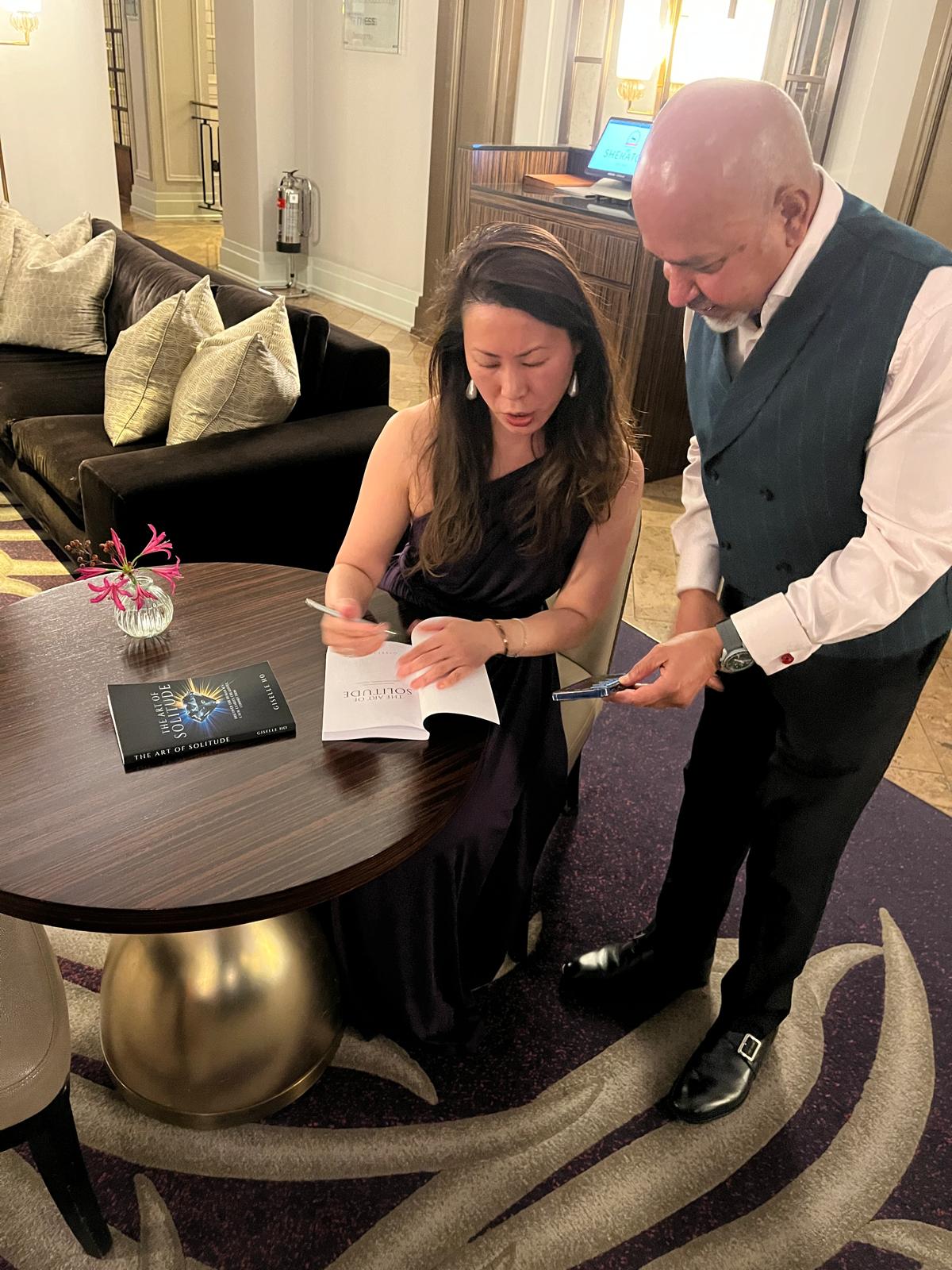 Giselle Ho signing a copy of The Art of Solitude